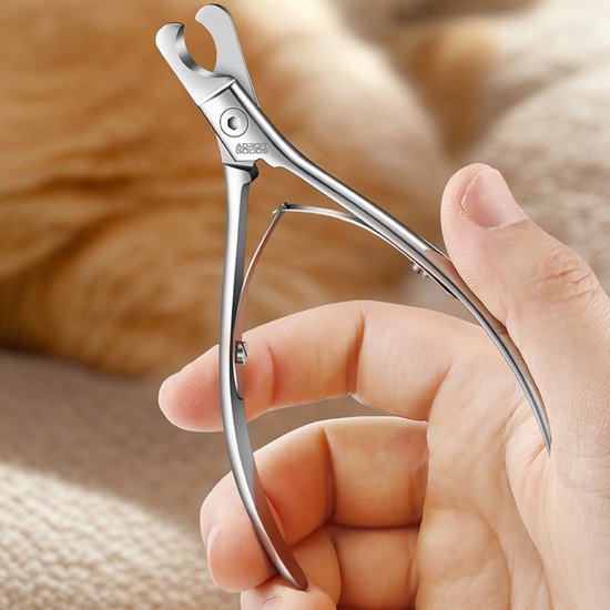 Hand houdt een glanzende metalen nagelknipper scherp en professioneel vormgegeven.