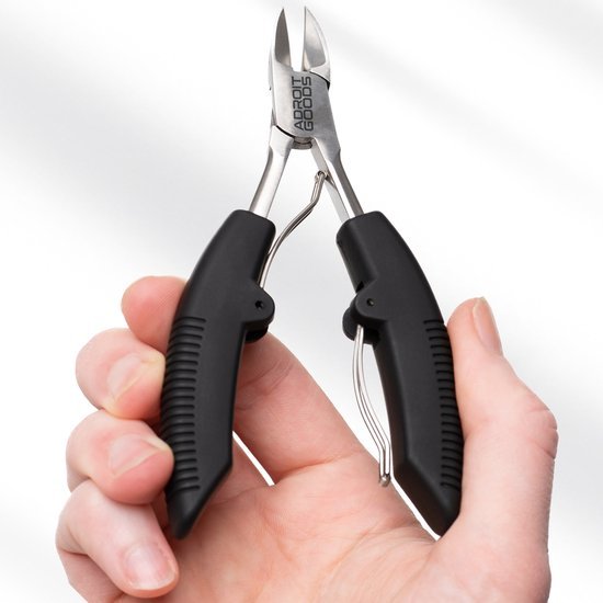 Hand houdt zwarte knipnageltang met metalen kop en merknaam Adroit Goods zichtbaar