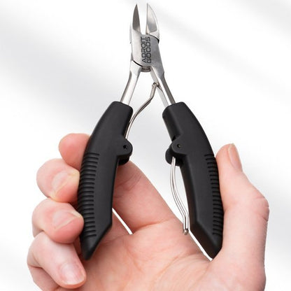 Hand houdt zwarte knipnageltang met metalen kop en merknaam Adroit Goods zichtbaar