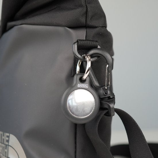 Zwarte siliconen houder voor apparaat met metalen metalen clip bevestigd aan rugzakband