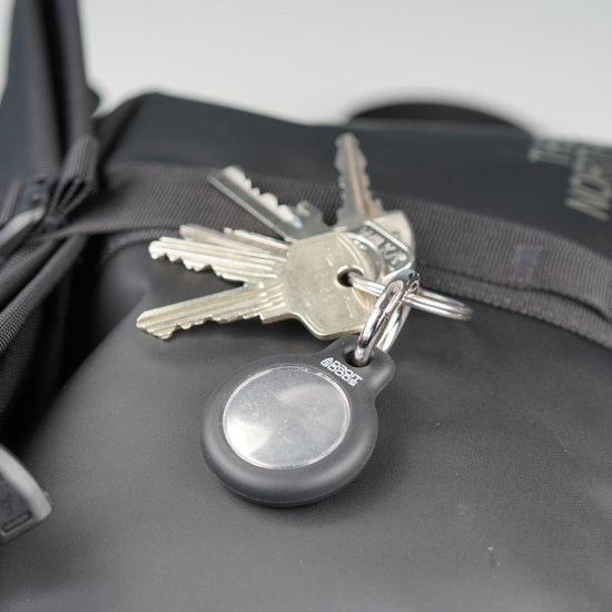 Sleutels aan een sleutelhangertje met AdroitGoods logo op een zwarte tas geplaatst