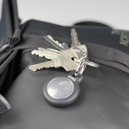 Sleutels aan een sleutelhangertje met AdroitGoods logo op een zwarte tas geplaatst