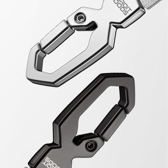 Twee metalen karabijnhaken, één zilver en één zwart, op een witte achtergrond.