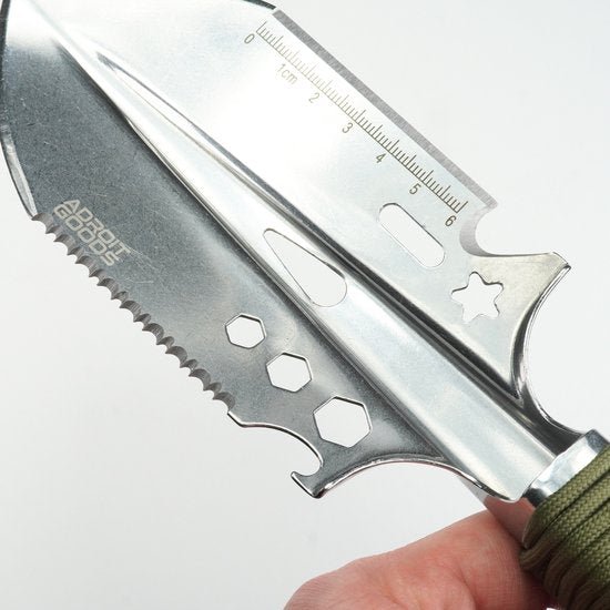 Close-up van roestvrijstalen multitool mes met zaagtand en meetlijn op lemmet