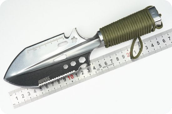 RVS tuinschep met gezaagde rand en olijfgroen handvat naast metalen liniaal.