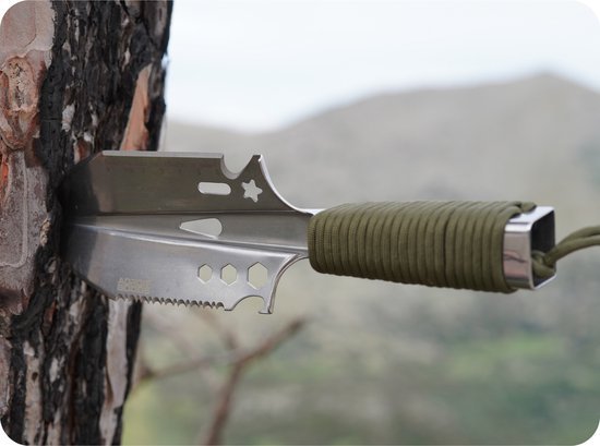 RVS multitool mes met geperforeerd lemmet en groene handgreep in een boomstam gesteekt