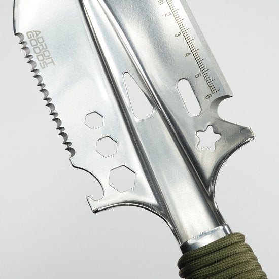 Close-up van een multifunctioneel, roestvrijstalen gereedschap met zaagblad en meetlint in centimeters.