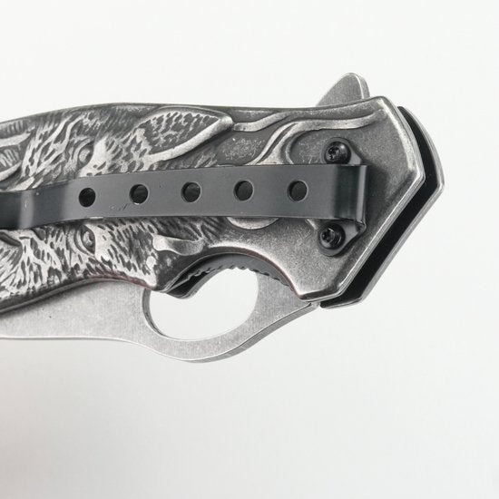 Close-up van een metalen inklapbaar mes met zwart clip en gedetailleerd handvatontwerp