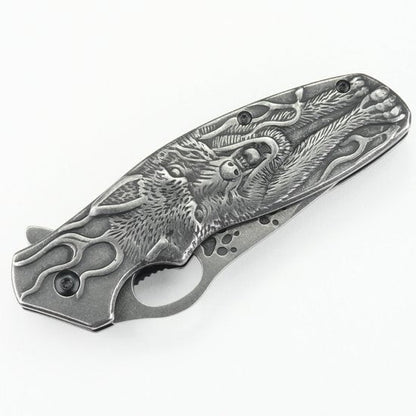 vouwmes met gedetailleerd gegraveerd ontwerp van een wolf en sierlijke patronen in metaal
