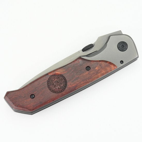 gevouwen zakmes met metalen behuizing en handvat van donker hout met gravure