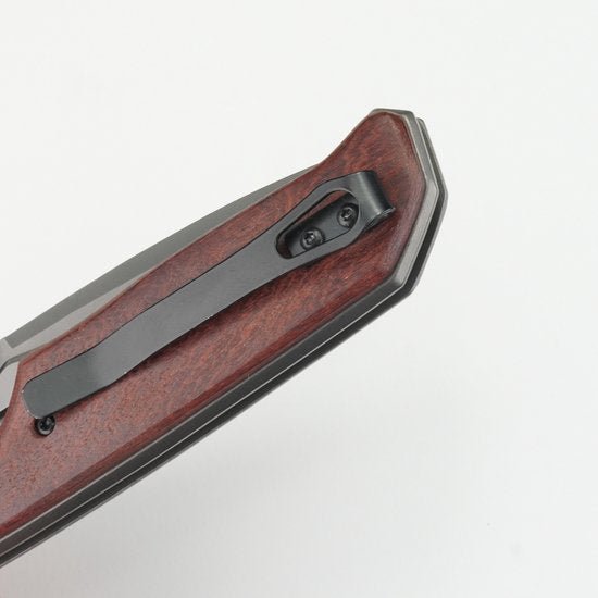 Hoekig mes met houten handvat en zwart metalen clip tegen witte achtergrond