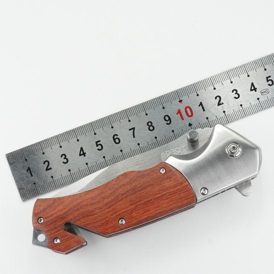 vouwmes met houten handvat naast metalen liniaal met metingen in centimeters