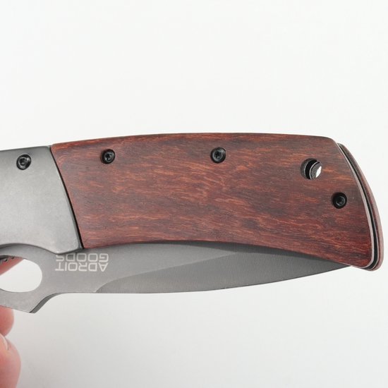 vouwmes met houten handvat en roestvrijstalen lemmet tegen een lichte achtergrond