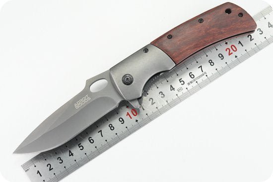 Vouwmes met houten handgreep en roestvrijstalen lemmet naast een liniaal voor maatvoering