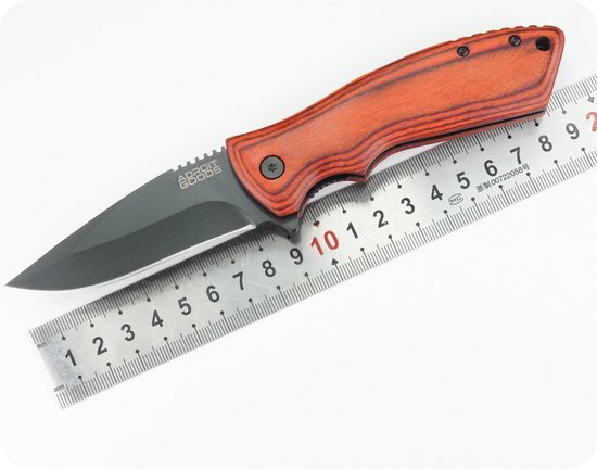 mes met zwart lemmet en houten handvat naast metalen liniaal op witte achtergrond