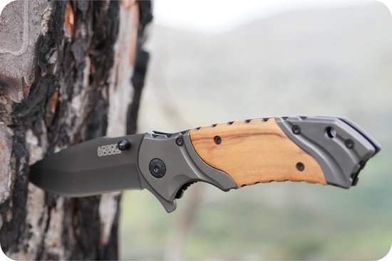 Stevige zakmes met houten handvat en zwart lemmet in een boomstam gestoken