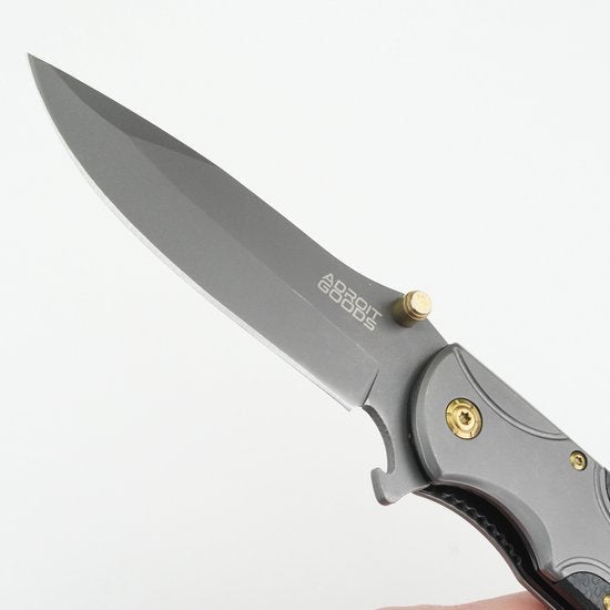 opentvouwbaar mes met grijs lemmet en zwart metalen handvat met gouden accenten