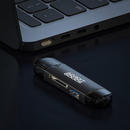 Zwarte AdroitGoods usb-hub met meerdere poorten naast een laptop op donkere ondergrond