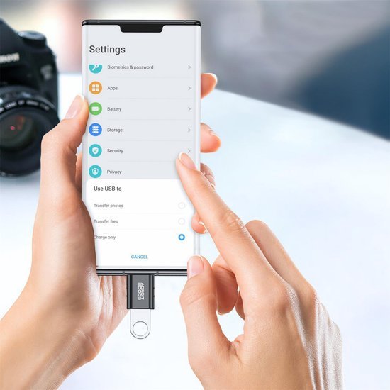 Hand die instellingen op smartphone aanraakt met USB-stick verbonden aan telefoonpoort