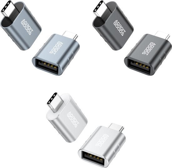 Vier metalen USB-C adapters in grijs, zwart en zilver met AdroitGoods logo zichtbaar