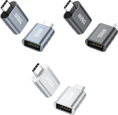 Vier metalen USB-C adapters in grijs, zwart en zilver met AdroitGoods logo zichtbaar