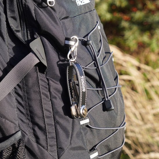 Zwarte rugzak met verstelbare band en sleutelhanger met metalen en lederen details