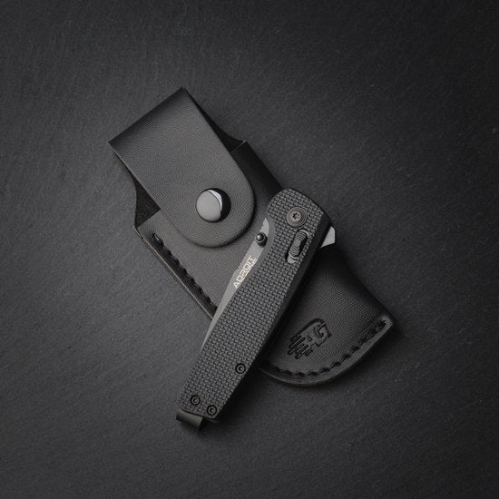 zwart inklapbaar mes met textuur handvat en leren hoes met drukknop sluiting op donkere achtergrond