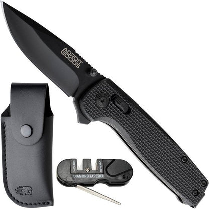 Opvouwbaar zwart zakmes met textuur handvat, leren schede en slijpsteen accessoire naast elkaar geplaatst