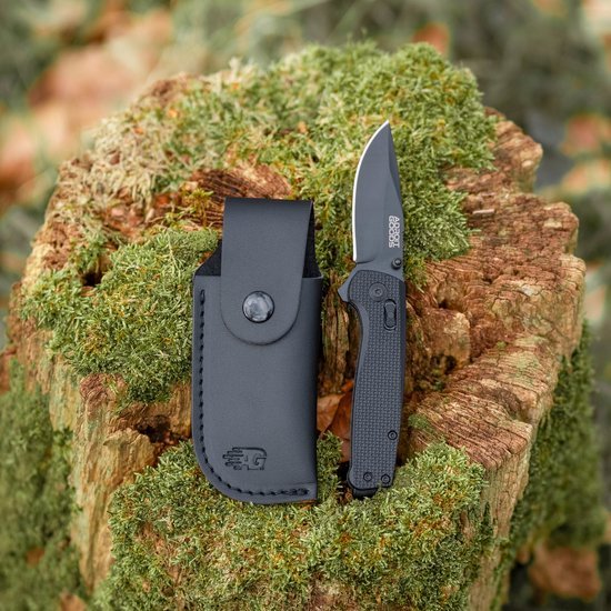 Opent mes op houten stronk met zwarte hoes en groen mos als achtergrond