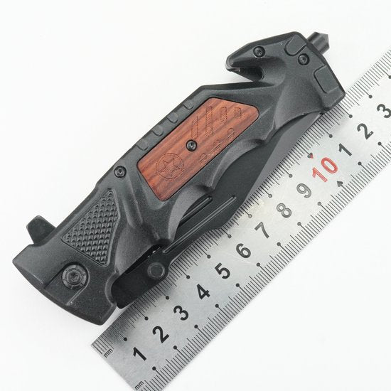 Zwart opvouwbaar gereedschap met houten accent naast een metalen liniaal met centimeters.