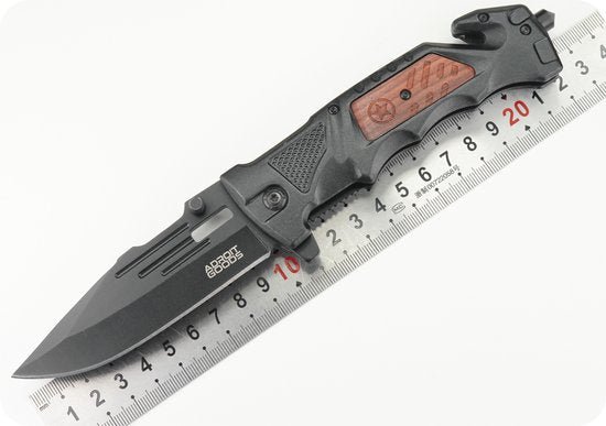 vouwmes met zwarte en houten handgreep naast een metalen liniaal met centimeterschaal