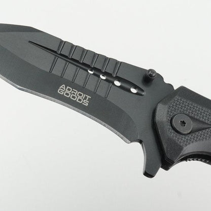 close-up van een zwart gevouwen mes met merknaam op het lemmet en een stevige handgreep