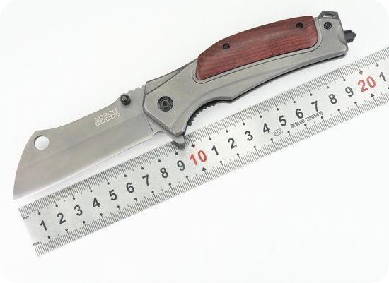 Stalen inklapbaar mes met houten handgreep naast metalen liniaal met centimeters en millimeters