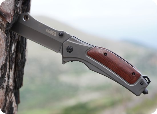 gevouwen zakmes met metalen blad en houten handgreep in een boomstam geplaatst