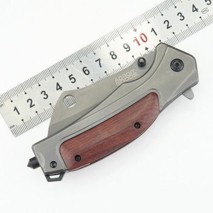 vouwmes met houten handvat en grijze metalen behuizing naast een metalen liniaal