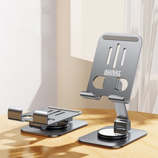 Twee verstelbare grijze metalen smartphonehouders van AdroitGoods op een houten oppervlak dichtbij een raam.