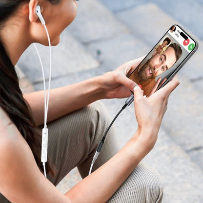 Vrouw met oordopjes voert videogesprek op smartphone tijdens buiten zitten op stenen vloer.