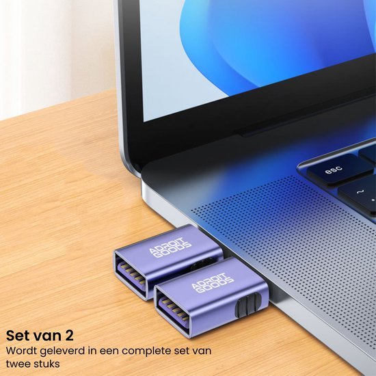 Twee paarse adapterstukken van AdroitGoods aangesloten op een laptop op een houten tafel