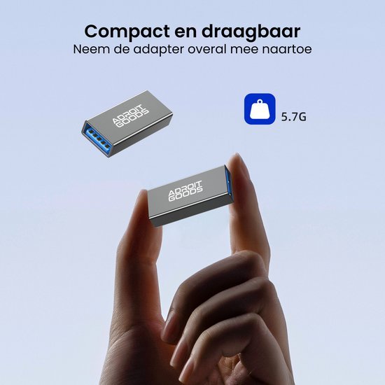 Hand houdt compacte en draagbare zilveren adapter van AdroitGoods met blauwe USB-poort