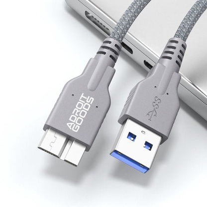 Grijze gevlochten USB 3.0-kabel met usb-a en micro-usb aansluitingen bij laptop