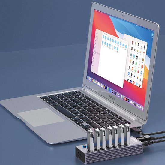 Laptop met open scherm en aangesloten hub met zes USB-sticks in een minimalistische setting