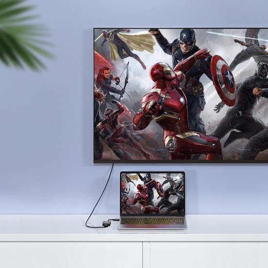 Laptop en televisie tonen dezelfde actiescène met superhelden in gevecht tegen neutrale achtergrond