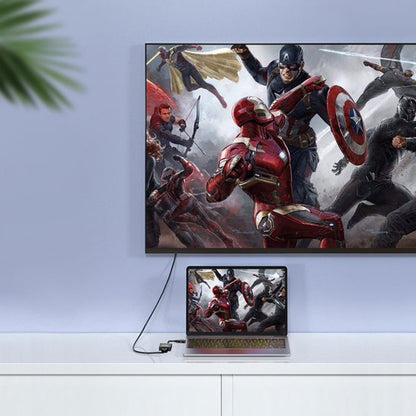 Laptop en televisie tonen dezelfde actiescène met superhelden in gevecht tegen neutrale achtergrond