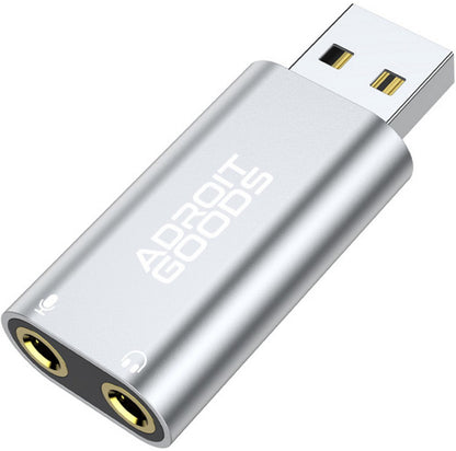 zilverkleurige usb-adapter met twee audio-aansluitingen en logo Adroit Goods