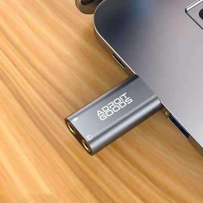 Grijze AdroitGoods usb-adapter met dubbele audio-ingang aangesloten op laptoppoort