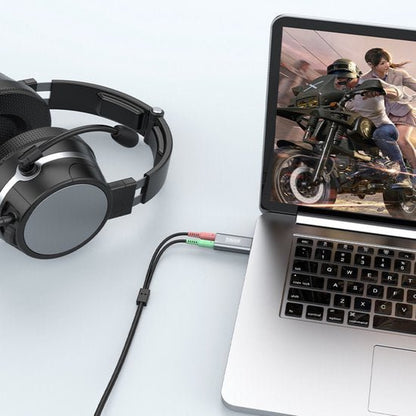 Hoofdtelefoon met microfoon aangesloten op laptop die een actiespel met motor toont