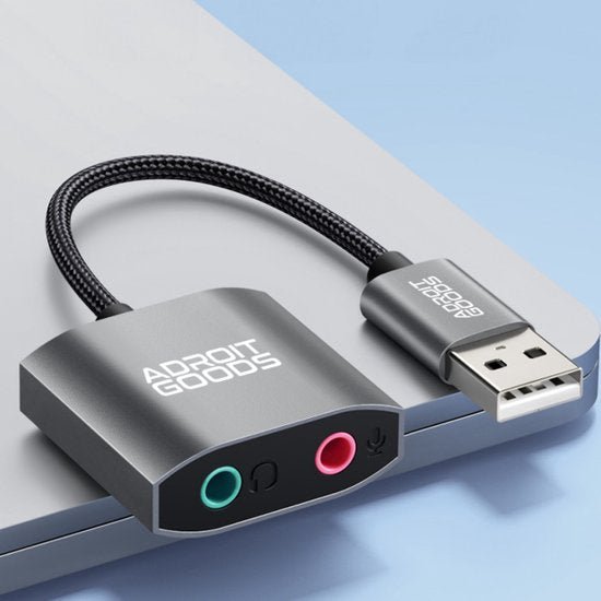 Zilverkleurige AdroitGoods audio adapter met USB aansluiting en twee 3,5 mm poorten voor microfoon en koptelefoon.