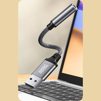 USB-adapter met gebogen kabel aangesloten op laptop met zwart toetsenbord en scherm