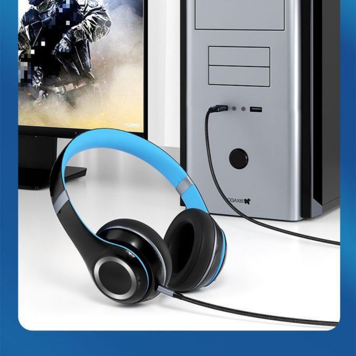 Zwart-blauwe koptelefoon aangesloten op een zilveren desktopcomputer met gamingbeeldscherm.
