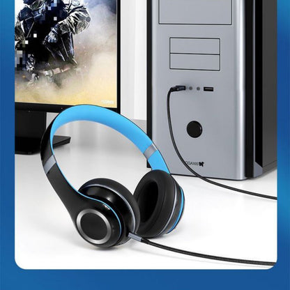 Zwart-blauwe koptelefoon aangesloten op een zilveren desktopcomputer met gamingbeeldscherm.